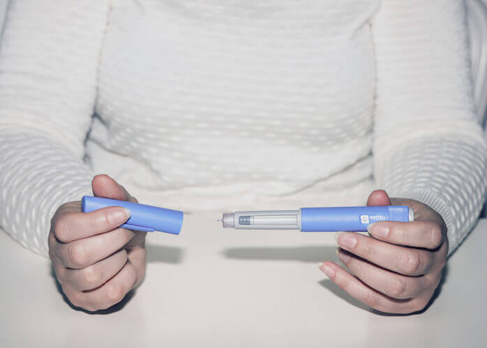 Woman holding an injection pen for diabetic