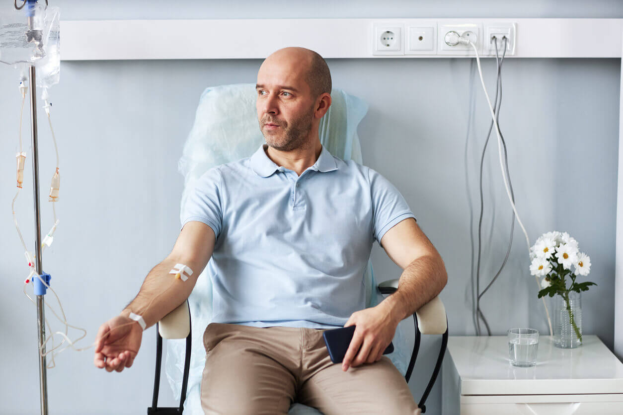 Adult man sitting in chair with IV drip during treatment session