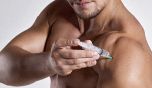 A man is depicted injecting testosterone into his shoulder.