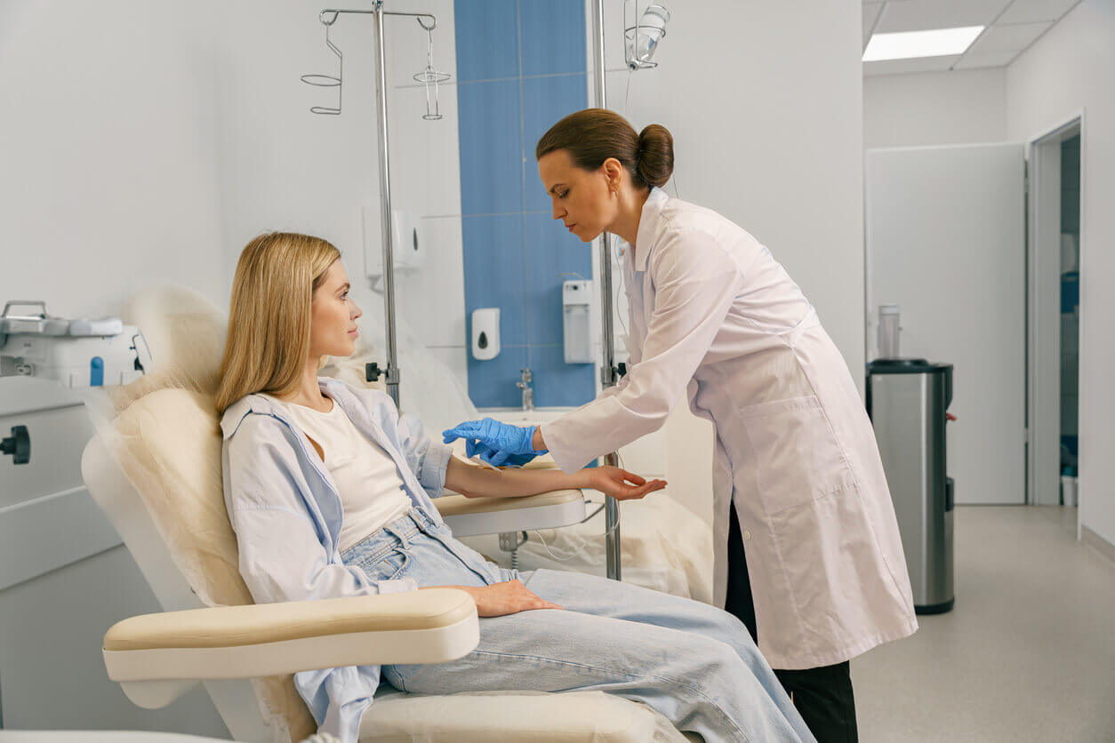 A doctor administering IV drip to a female patient in hospital to enhance her immune system.
