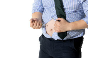 A man who is overweight is injecting himself with weight loss injections.
