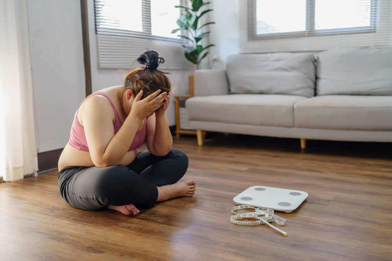 An obese woman is frustrated and unhappy with her weight loss journey due to repeated dieting failures.